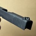 Glock 48 slide assembly with barrel and recoil spring in black for tactical use.