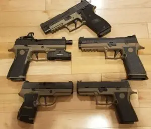 Tactical handgun collection displayed on polished wooden surface, showcasing diverse firearm designs.