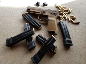 Tactical handgun with magazines and bullet casings, ready for shooting activities.