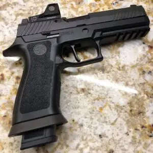 Sleek modern semi-automatic handgun on polished granite countertop, showcasing textured grip and tactical design.