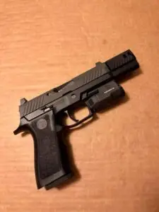 Tactical handgun with light attachment on wooden surface, designed for versatility and performance.