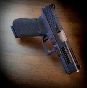 Sleek black handgun on wooden surface, highlighting modern design and ergonomic grip.