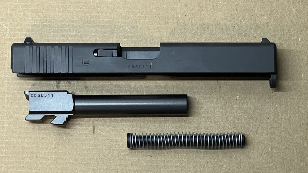 Disassembled Glock 17 components: slide, barrel, and recoil spring for every shooter.